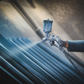 Spray coating being applied to panels